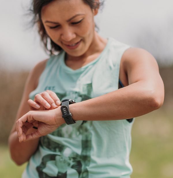 A female runner checks her Garmin GPS watch