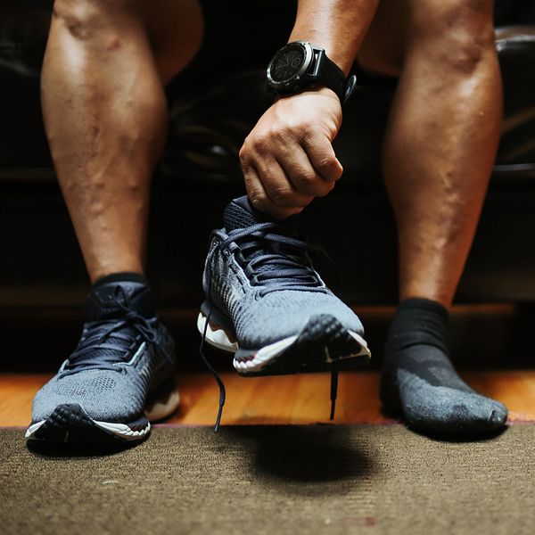 A runner puts on a pair of Mizuno running shoes